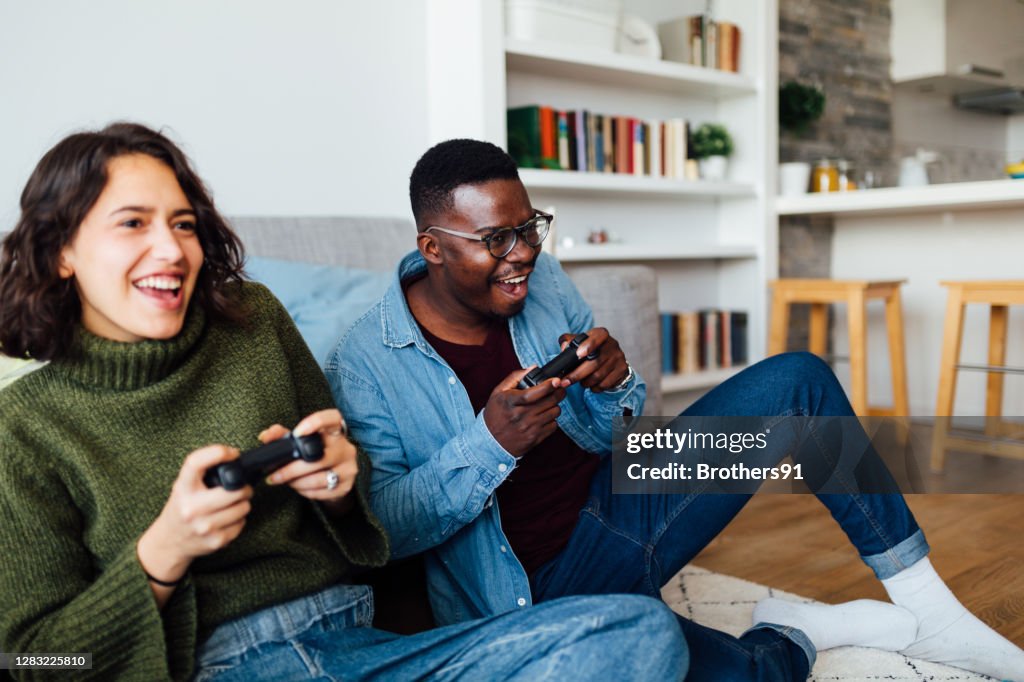 Feliz joven pareja diversa relajarse en casa