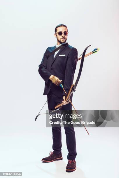 businessman holding bow and arrow - pijl en boog stockfoto's en -beelden