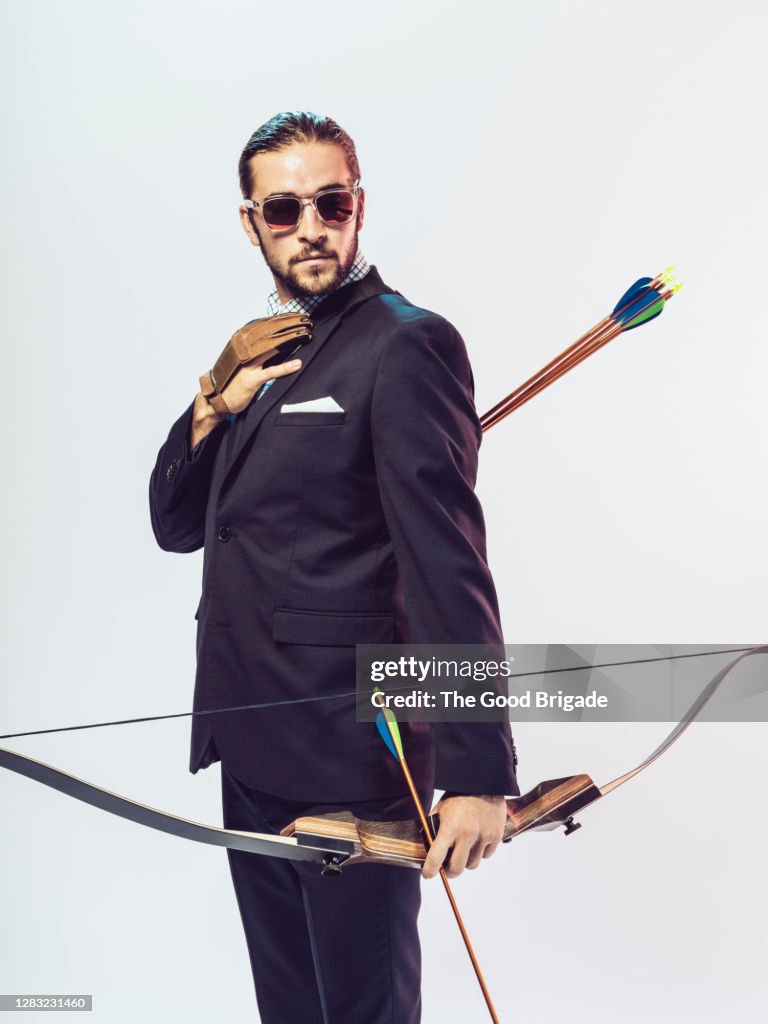 Portrait of businessman holding a bow and arrow
