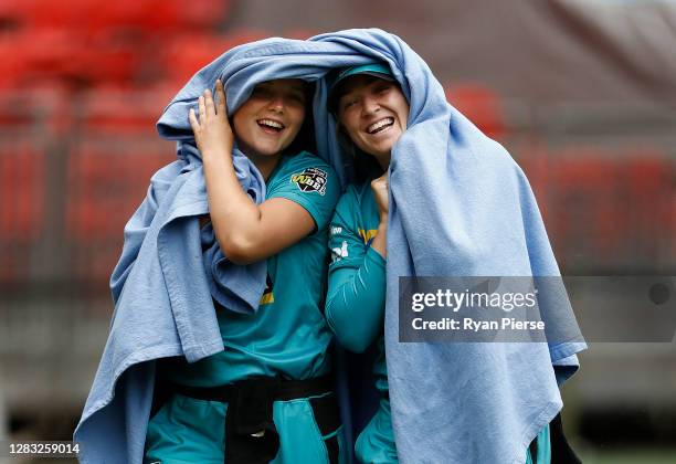 Amelia Kerr and Maddy Green of the Heat keep warm during a rain delay during the Women's Big Bash League WBBL match between the Sydney Thunder and...