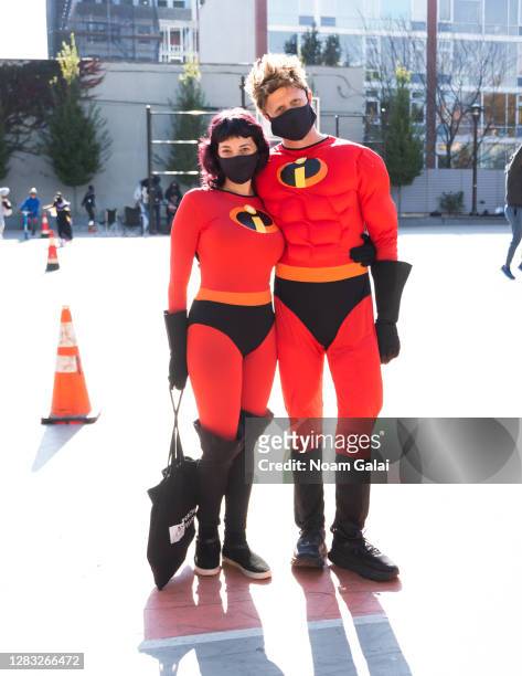 People wear costumes of Elastigirl and Mr. Incredible from the The Incredibles in Crown Heights on October 31, 2020 in New York City. Many Halloween...