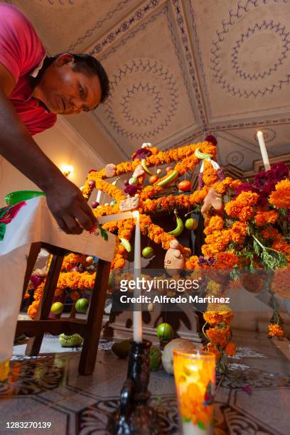 Man places a lit candle on an altar inside a church ahead of Day of the Dead celebrations on November 1, 2008 in Janitzio, Mexico. Considered one of...