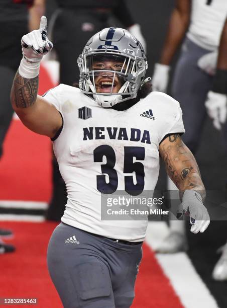 Running back Toa Taua of the Nevada Wolf Pack celebrates after he ran for a 4-yard touchdown against the UNLV Rebels in the second half of their game...