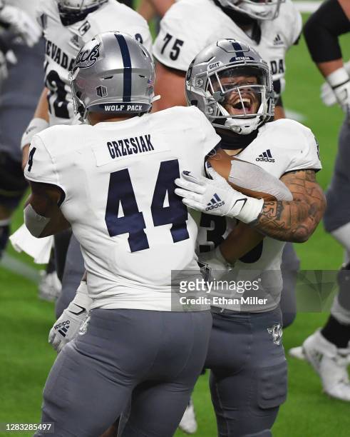 Defensive end Daniel Grzesiak and running back Toa Taua of the Nevada Wolf Pack celebrate after Taua ran for a 4-yard touchdown against the UNLV...