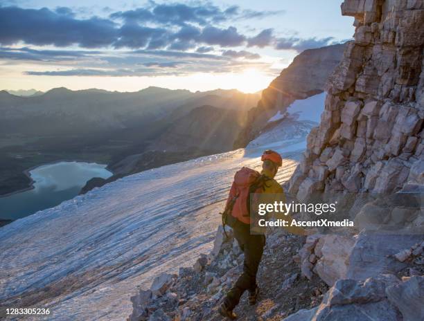 randonnées de jeune homme le long du sentier de montagne au lever du soleil - manitoba stock photos et images de collection