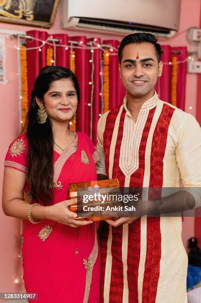 young indian couple celebrating diwali - man giving gift box to woman. - raksha bandhan stock pictures, royalty-free photos & images