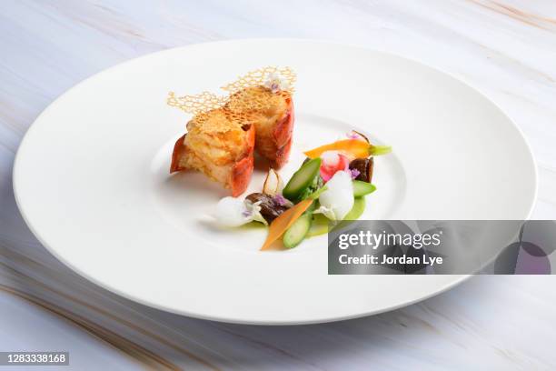 lobster, garnished with chestnut confit and seasonal vegetables - gastronomico foto e immagini stock