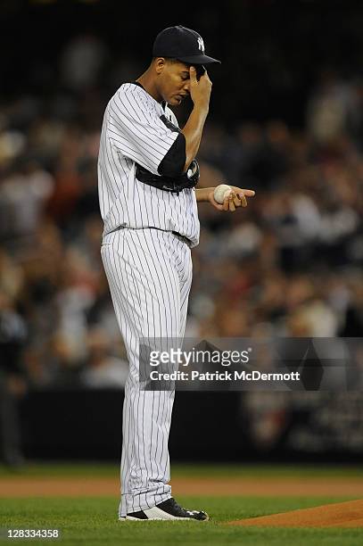 Starting pitcher Ivan Nova of the New York Yankees rubs his forehead as he gets set to throw a pitch against the Detroit Tigers during Game Five of...