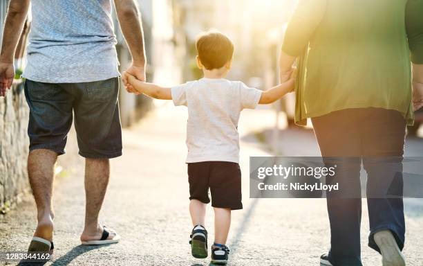 familia caminando juntos en la acera - espalda humana fotografías e imágenes de stock
