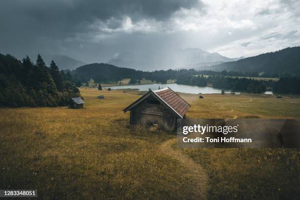 cabin at lake geroldsee with bavarian alps and rain clouds on a rainy autumn day - hütte stock-fotos und bilder