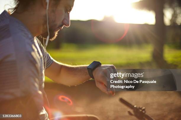 cyclist checking smart watch - effort face stock pictures, royalty-free photos & images