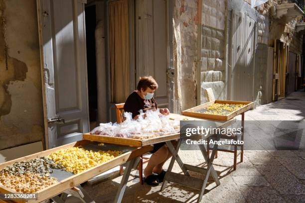 vrouw van bari die de orecchiettepasta in de straat maakt - bari italy stockfoto's en -beelden