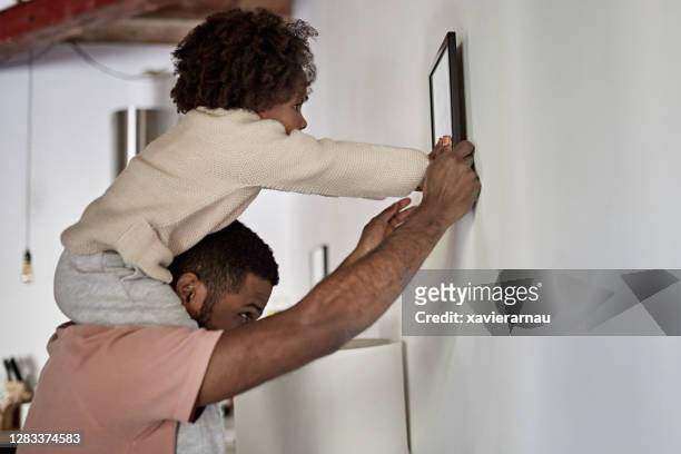 father with young daughter on his shoulders hanging picture - hanging stock pictures, royalty-free photos & images