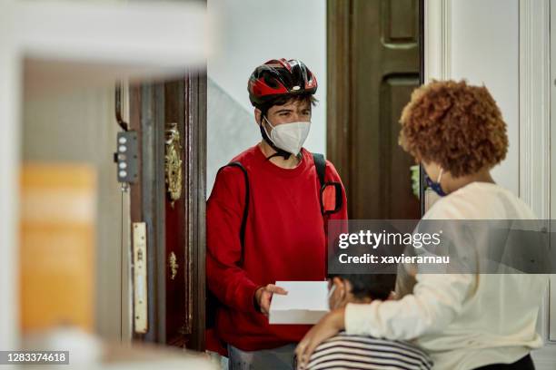 bicycle messenger delivering pizza to residential customer - pizza delivery stock pictures, royalty-free photos & images