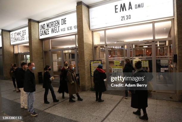 Moviegoers arrive at Kino International movie theater prior to a screening of the film "Morgen die Ganze Welt" on the last night that cinemas are...