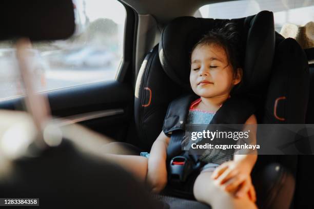 little cute girl sleeping on car seat in car - baby car seat stock pictures, royalty-free photos & images