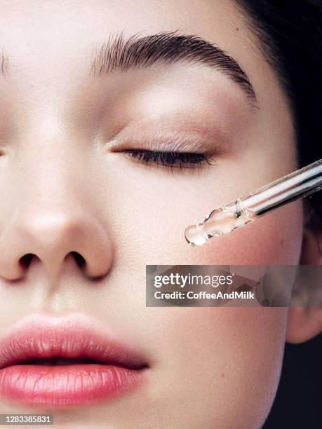 close-up portrait of beautiful girl getting skin anti aging treatment - face oil stock pictures, royalty-free photos & images