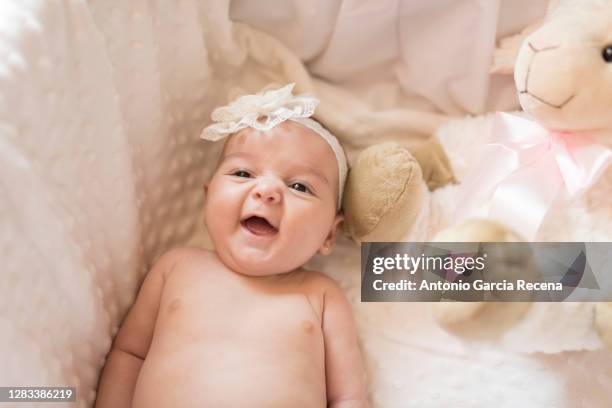 little baby laughing in cot with baptism ceremonial diadem - bautizo fotografías e imágenes de stock