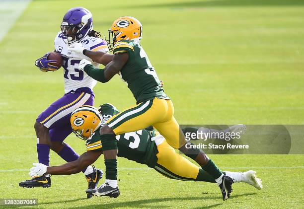 Dalvin Cook of the Minnesota Vikings runs the ball as Adrian Amos of the Green Bay Packers and Josh Jackson of the Green Bay Packers defend during...