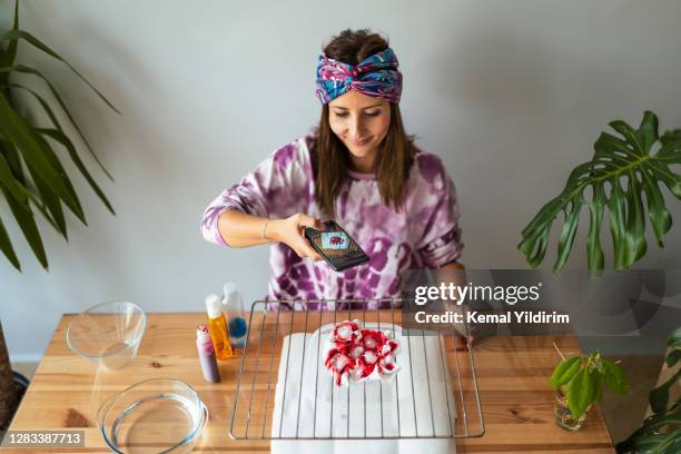 young woman making tie dye at living room - dye clothes stock pictures, royalty-free photos & images