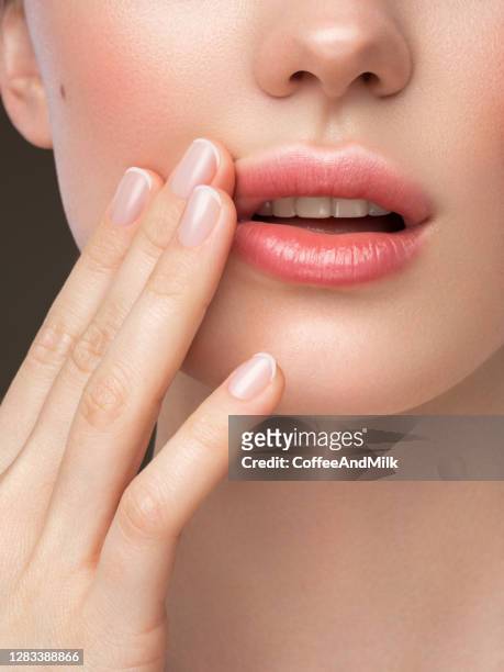 part of woman's face. woman's lips, nose and hand. soft skin. - body care and beauty stock pictures, royalty-free photos & images