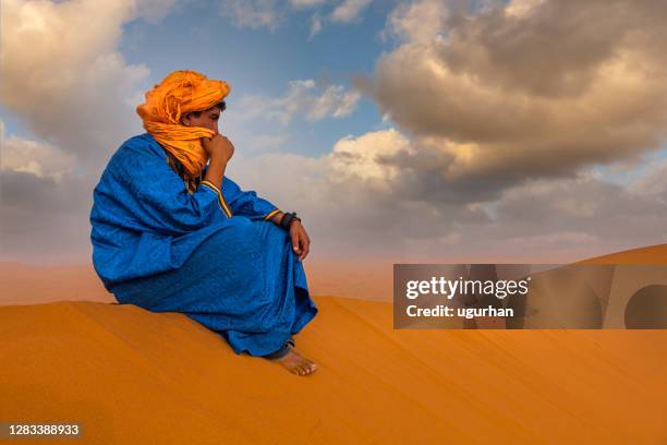 a berber man on the dune of the sahara desert. - tuareg stock pictures, royalty-free photos & images