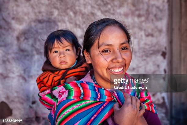 mujer peruana con su bebé en la espalda en pisac cerca de cuzco - cultura indigena fotografías e imágenes de stock