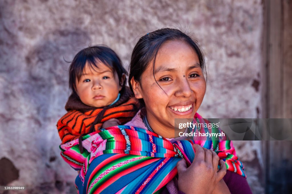 Peruvian woman with her baby on the back in Pisac near Cuzco