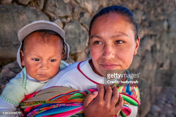 peruanische frau mit ihrem baby auf dem rücken in der nähe von ollantaytambo - peruanische kultur stock-fotos und bilder