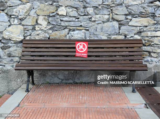 social distancing on a public bench during the coronavirus pandemic in italy - panchina stock pictures, royalty-free photos & images