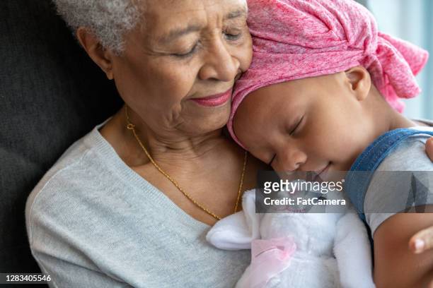 de grootmoeder omhelst kleindochter met kanker - grandma sleeping stockfoto's en -beelden