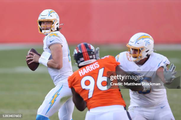 Quarterback Justin Herbert of the Los Angeles Chargers looks to pass against Shelby Harris of the Denver Broncos in the second quarter of the game at...