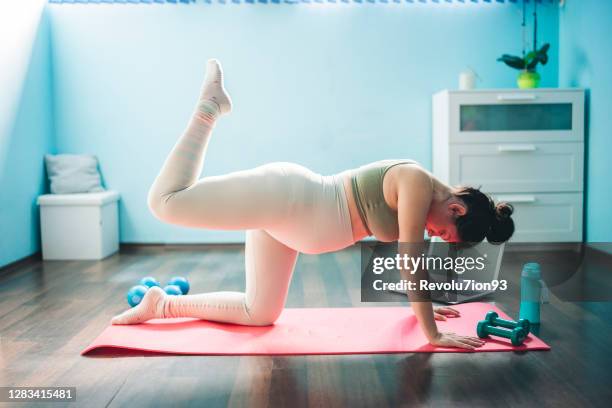 young and beautiful pregnant woman exercises at home - prenatal yoga stock pictures, royalty-free photos & images