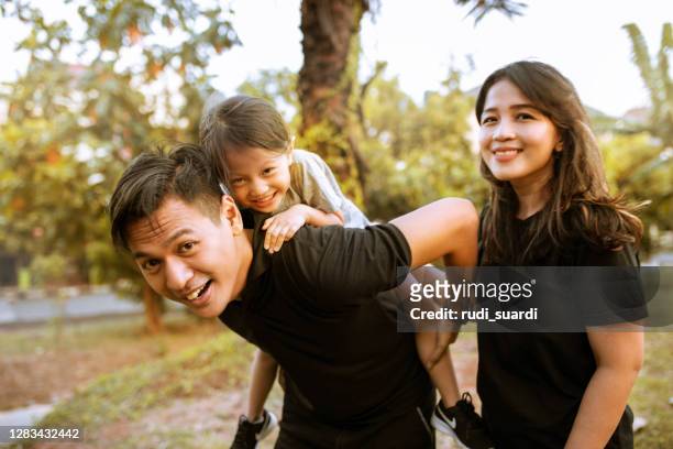 une photo d’une famille asiatique marchant autour du parc public - family garden play area photos et images de collection