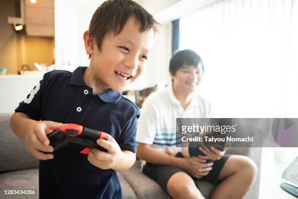 a boy playing video games in the living room. - pre game stockfoto's en -beelden