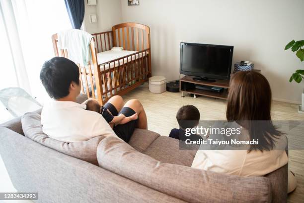 a family of four relaxing in the living room on the weekend - リビング　家族　日本 ストックフォトと画像