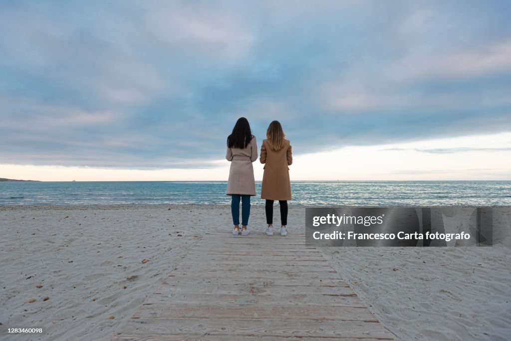 Two women on the beach on an autumn day