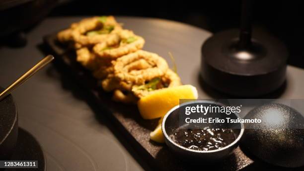 calamari ring with squid ink dip sauce - dark fruit ink stock pictures, royalty-free photos & images