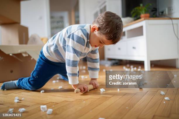 kleinkind spielt mit nudelholz und verpackung erdnuss während hausumzug - push pin stock-fotos und bilder