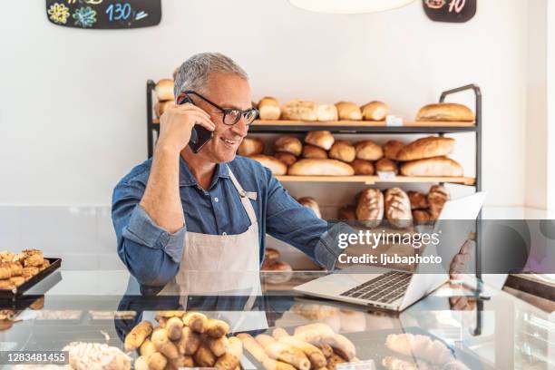 man using devices for online business order at bakehouse - coffee shop owner stock pictures, royalty-free photos & images