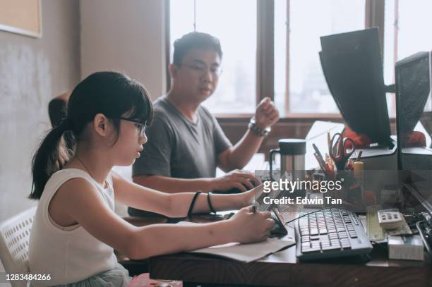 asian chinese young girl studying at home in her father's home office attending online class