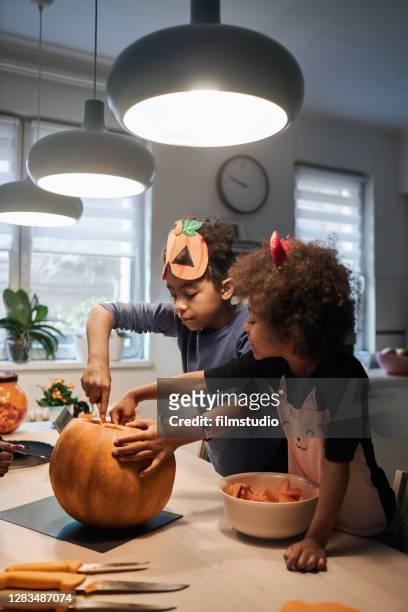 making jack-o'-lantern for halloween - bad brother stock pictures, royalty-free photos & images