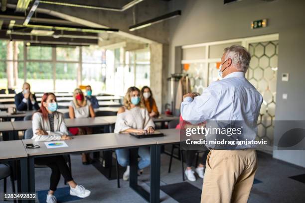 moderator spricht während des trainingsvorschulkurses vor publikum - die neue normalität stock-fotos und bilder