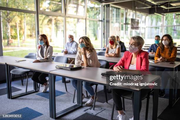 business people attending a seminar at convention center - spectator mask stock pictures, royalty-free photos & images