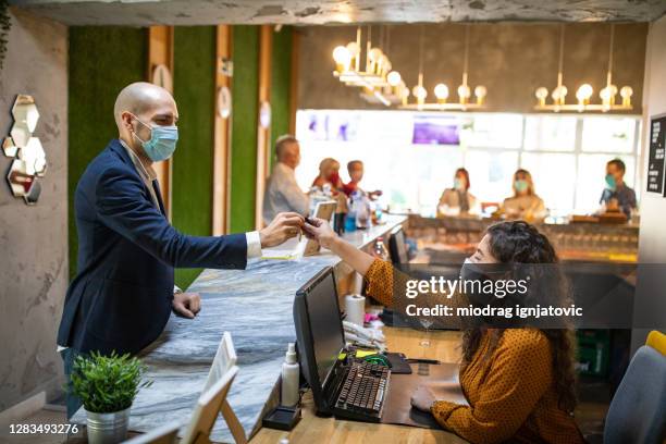 receptionist giving room keys to guest at reception - hotel key stock pictures, royalty-free photos & images