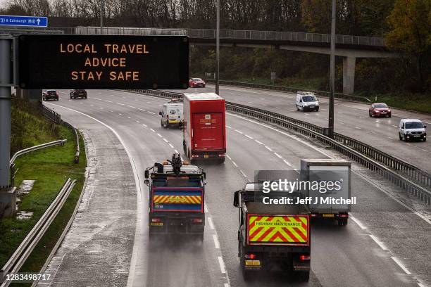 Motorists pass a motorway gantry sign on the M8 on November 02, 2020 in Glasgow, Scotland. Scotland is proceeding with a regional, five-tier approach...