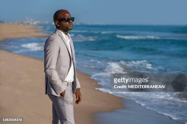 african american tourist suit businessman relax on the beach - best sunglasses for bald men stock pictures, royalty-free photos & images