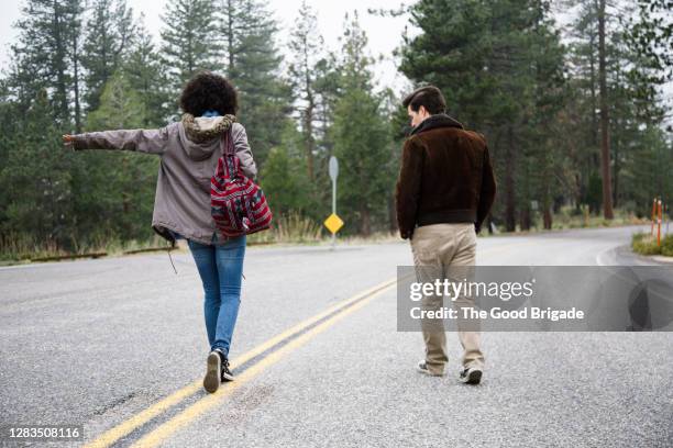 young couple walking in middle of empty road - arcadia california stock pictures, royalty-free photos & images