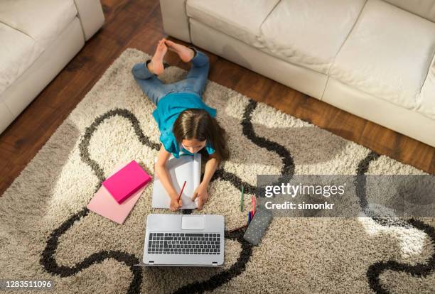 meisje dat online schoolklasse van huis bijwoont - barefoot feet up lying down girl stockfoto's en -beelden