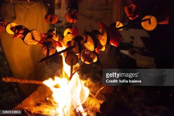 friends grilling skewers over bonfire at night - night picnic stock pictures, royalty-free photos & images